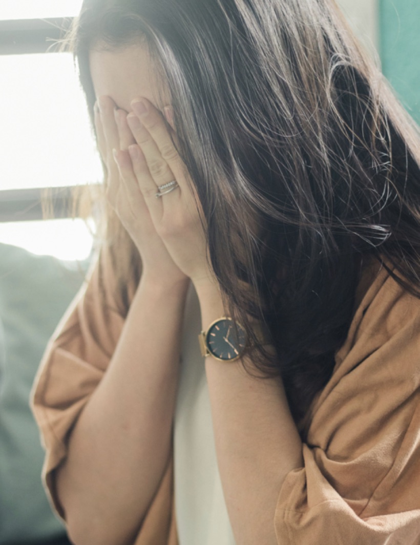 Femme repliée sur elle-même, le regard ailleurs