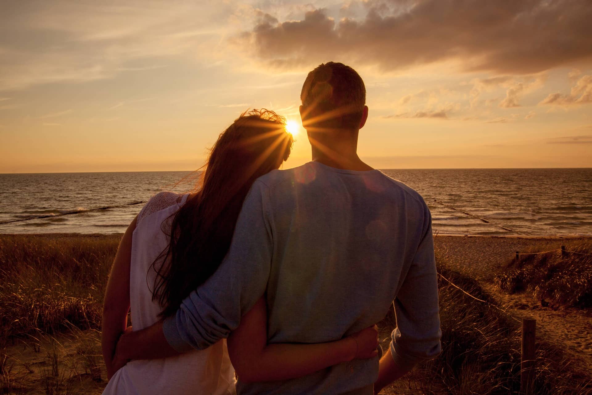 Un couple enlacé au coucher de soleil